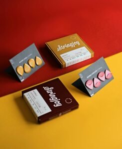 A vibrant flat lay of guitar picks and packaged string sets on red and yellow background.