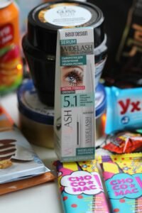 Eye serum amidst colorful snacks, highlighting beauty and lifestyle appeal.