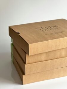 Three stacked brown cardboard boxes on a white background showcasing sustainable packaging.