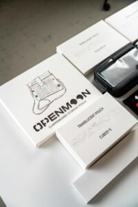 Top-down view of minimal packaging featuring Openmoon storage pouches and accessories.